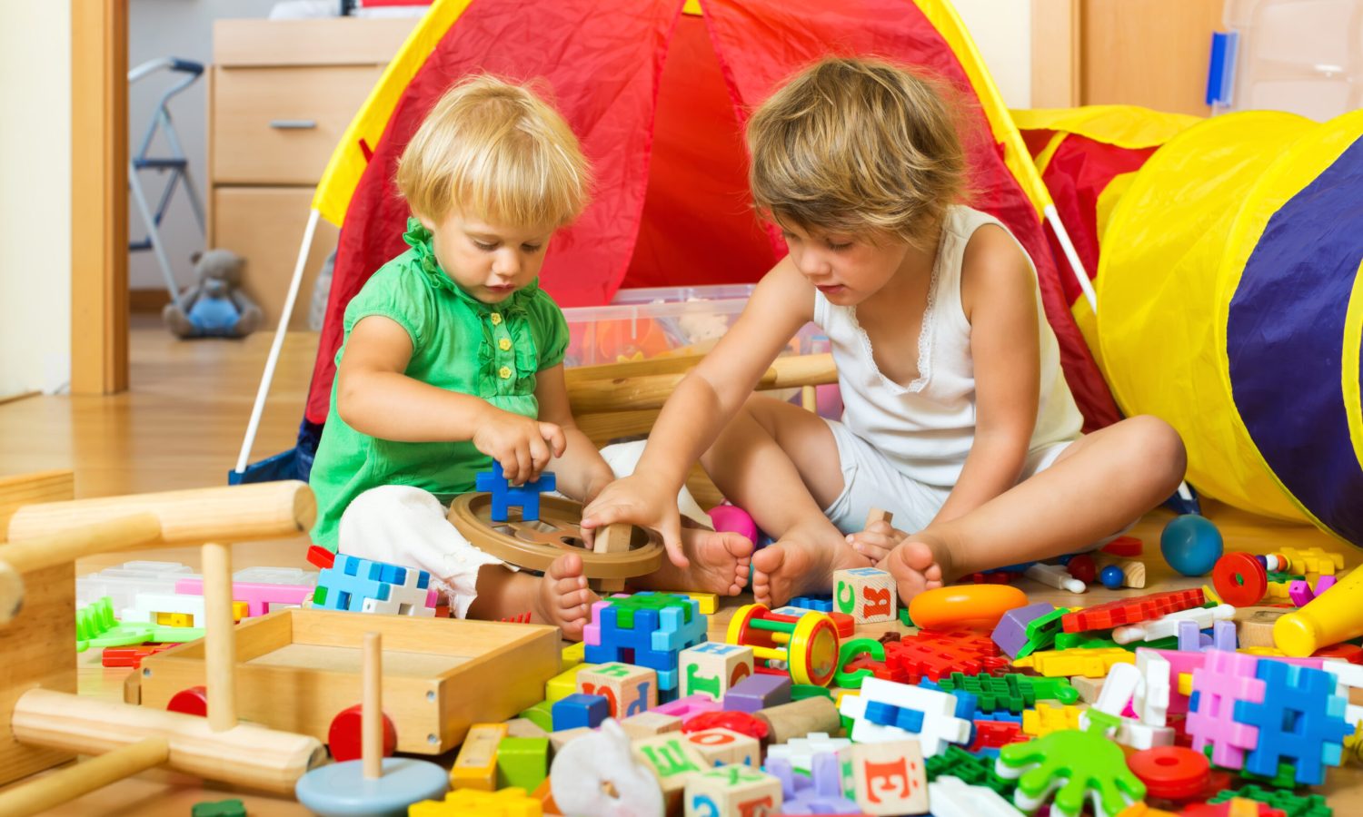 Calm children playing with  toys in home interior