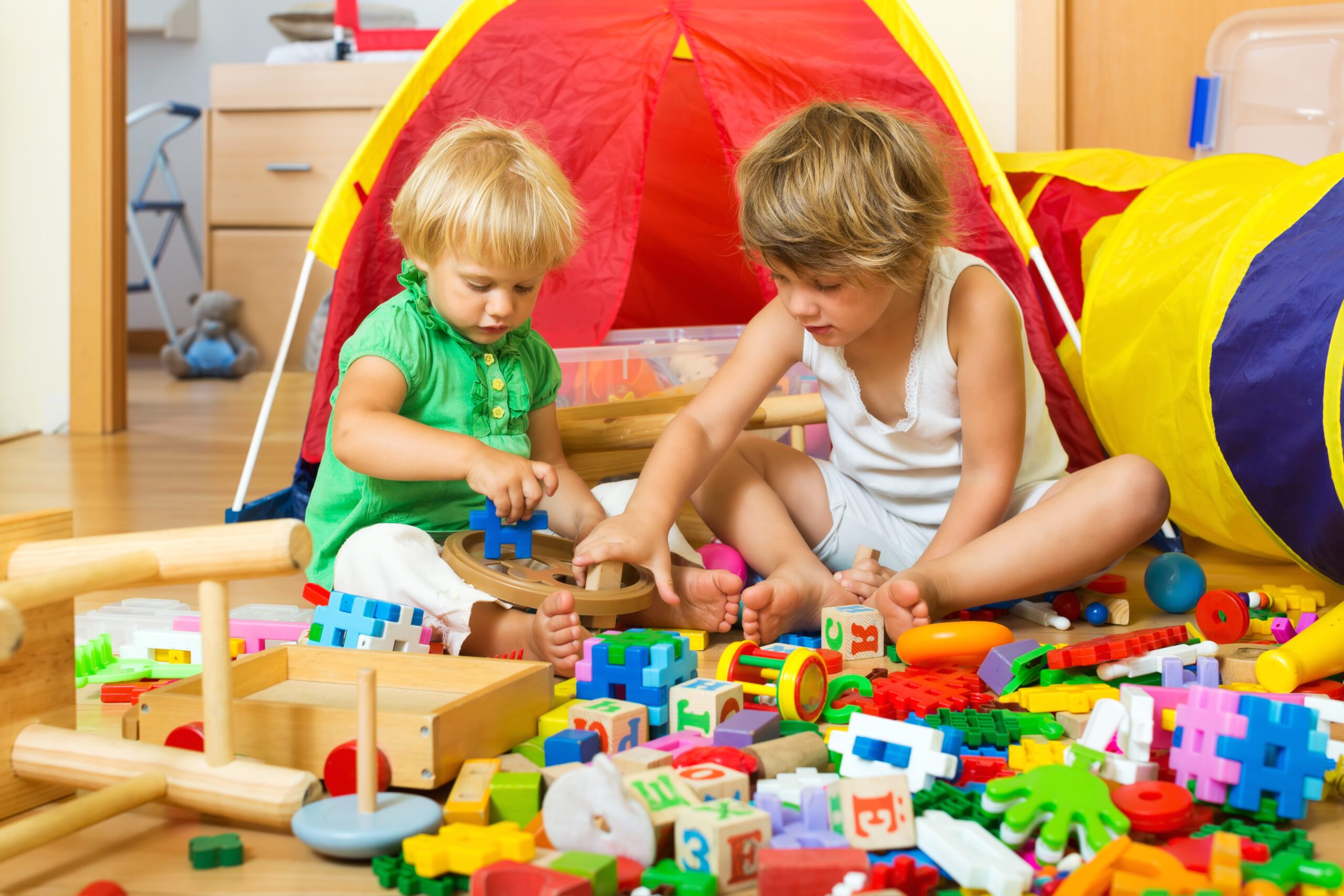 Calm children playing with  toys in home interior